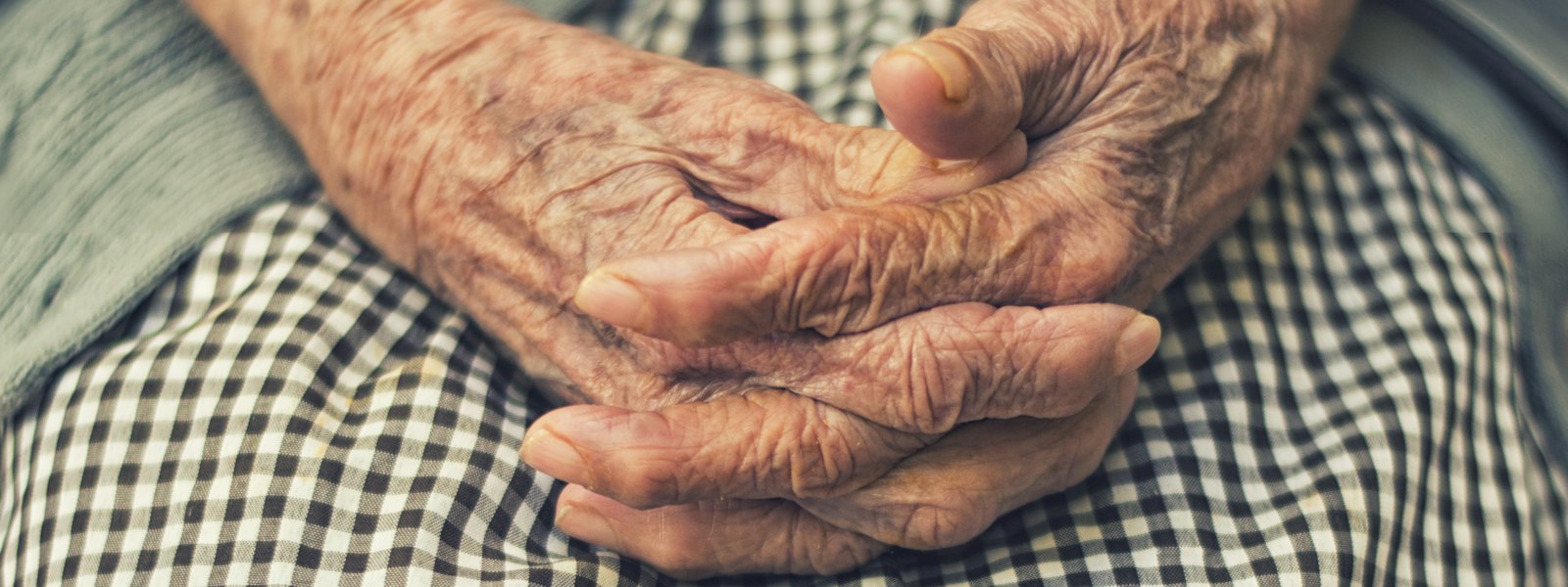 An older woman's hands folded in her lap