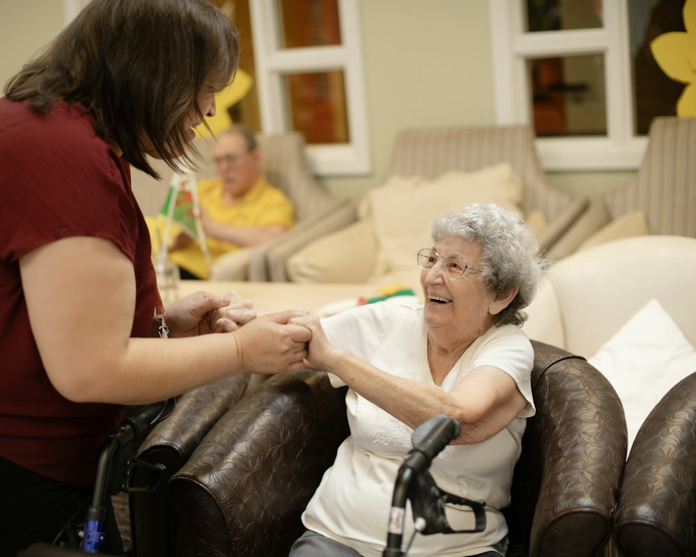 A caregiver helping an older woman with her walker